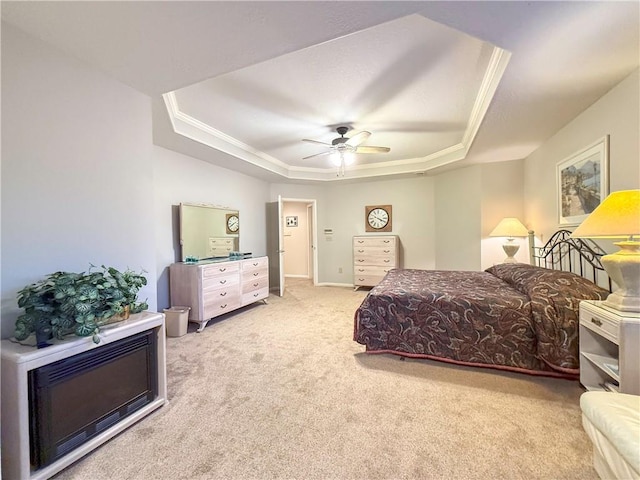 carpeted bedroom featuring ceiling fan, crown molding, and a tray ceiling