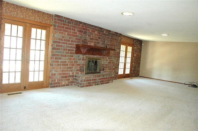 unfurnished living room featuring carpet, a wealth of natural light, and a fireplace