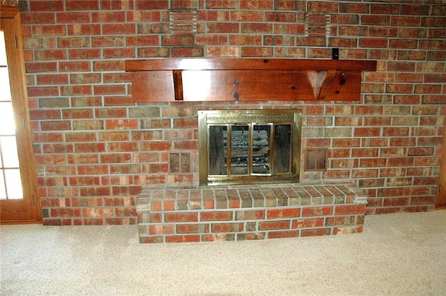 room details featuring carpet flooring and a brick fireplace