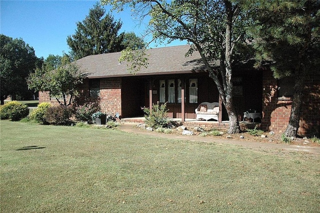 view of front of house featuring covered porch and a front lawn