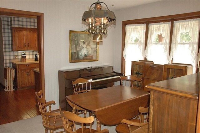 dining area featuring hardwood / wood-style floors and an inviting chandelier