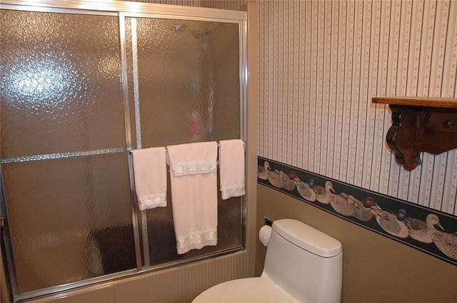 bathroom featuring enclosed tub / shower combo and toilet