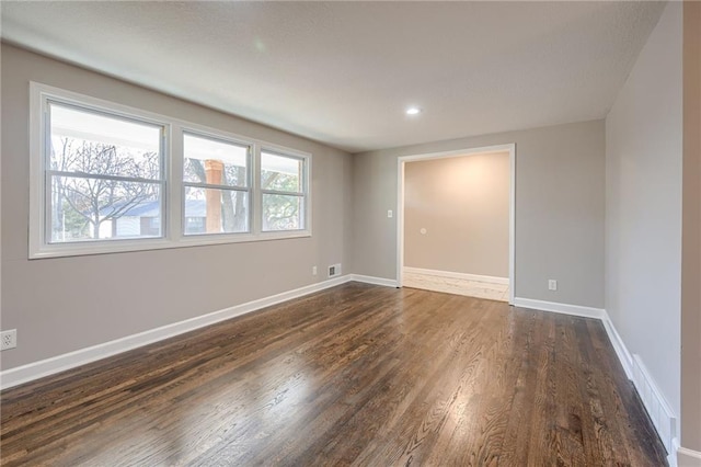 empty room with dark hardwood / wood-style flooring