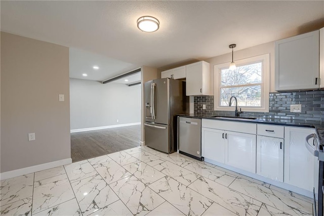 kitchen featuring pendant lighting, sink, tasteful backsplash, white cabinetry, and stainless steel appliances