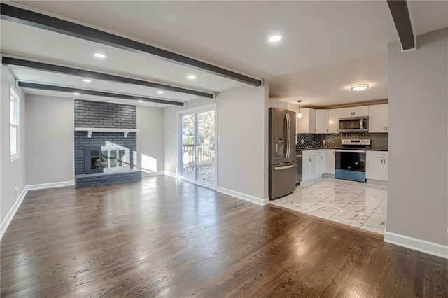 unfurnished living room featuring a fireplace, beam ceiling, and light hardwood / wood-style flooring