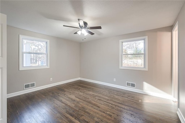 spare room with plenty of natural light, dark hardwood / wood-style floors, and ceiling fan