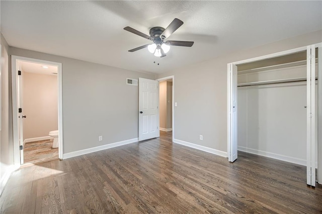 unfurnished bedroom with dark hardwood / wood-style floors, ceiling fan, connected bathroom, and a closet