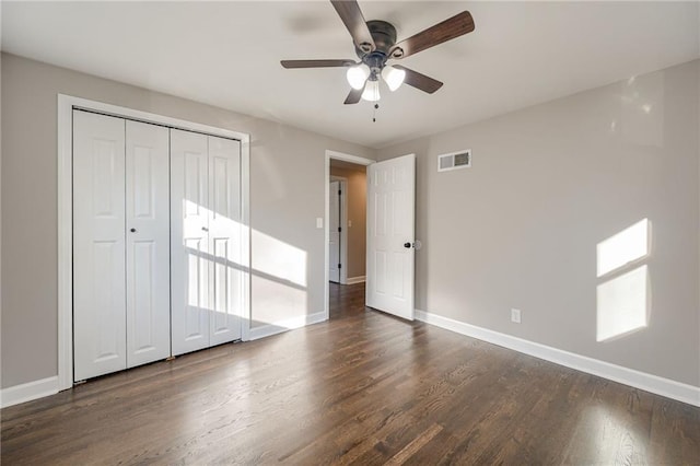 unfurnished bedroom featuring a closet, dark hardwood / wood-style floors, and ceiling fan