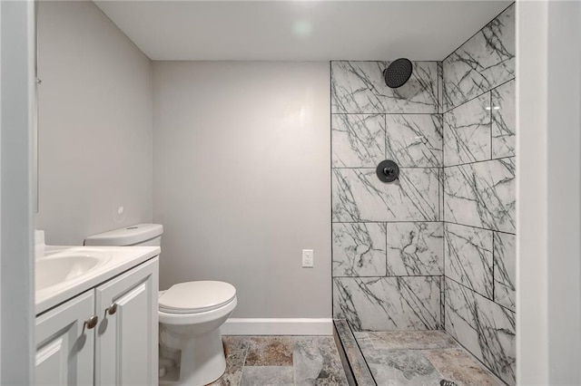 bathroom featuring tiled shower, vanity, and toilet