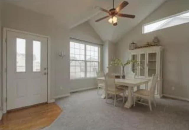 unfurnished dining area featuring carpet, lofted ceiling, and ceiling fan