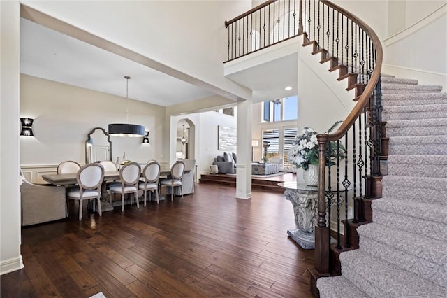 entrance foyer with a towering ceiling and dark wood-type flooring