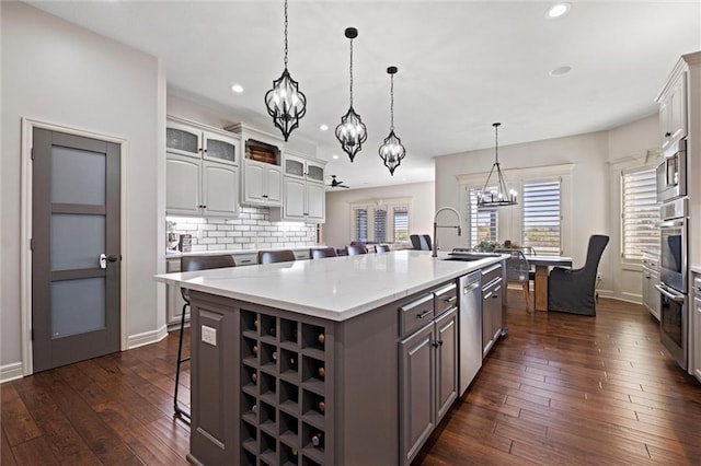 kitchen featuring a kitchen bar, sink, a center island with sink, dark hardwood / wood-style floors, and white cabinetry