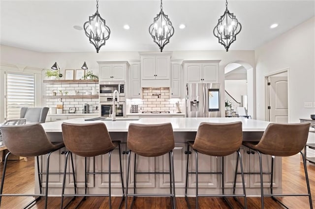 kitchen featuring white cabinets, a spacious island, hanging light fixtures, and appliances with stainless steel finishes