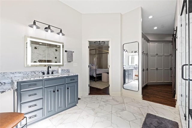 bathroom featuring vanity, a shower with shower door, and wood-type flooring