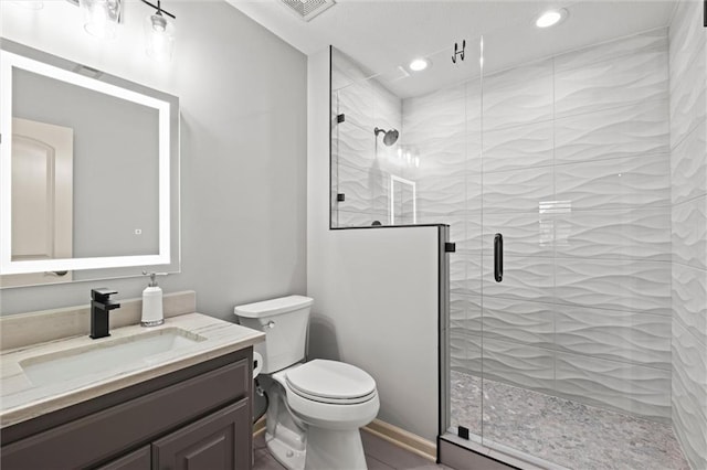 bathroom with vanity, an enclosed shower, and toilet