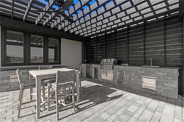 view of patio with an outdoor kitchen, a pergola, sink, and grilling area