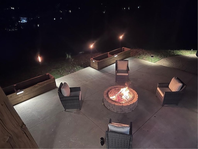 patio at night featuring an outdoor fire pit