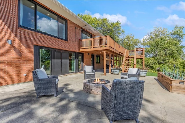 view of patio featuring a wooden deck and an outdoor living space with a fire pit