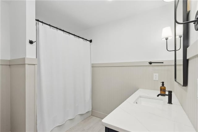 bathroom featuring shower / bath combination with curtain, vanity, and hardwood / wood-style floors