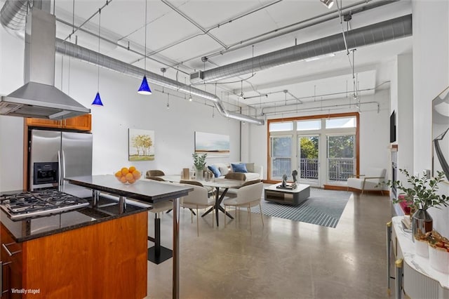 kitchen with pendant lighting, concrete floors, stainless steel appliances, range hood, and dark stone counters