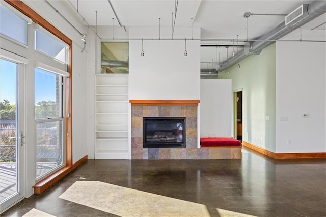 unfurnished living room with a tiled fireplace