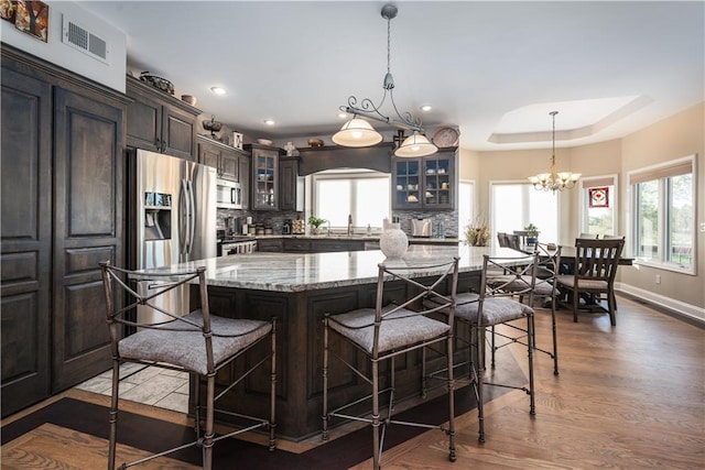 kitchen featuring a spacious island, stainless steel appliances, tasteful backsplash, and a healthy amount of sunlight