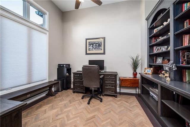 office area with light parquet floors and ceiling fan