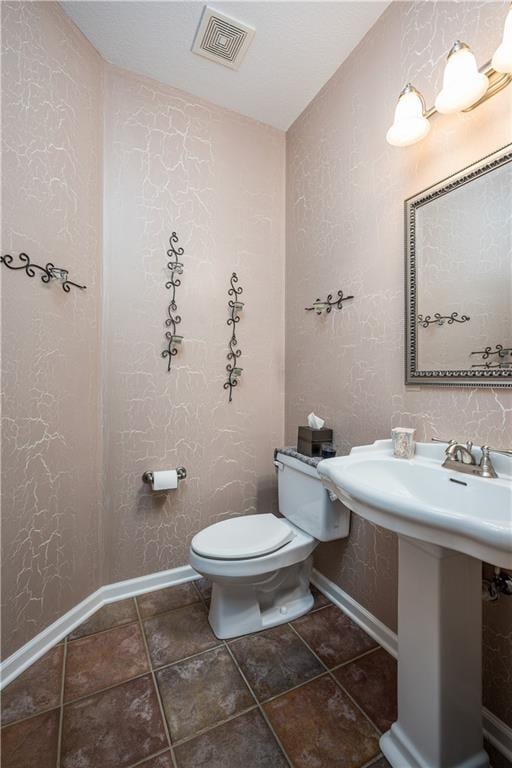 bathroom featuring sink, lofted ceiling, and toilet