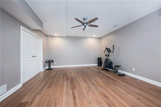 workout area with ceiling fan and light hardwood / wood-style floors