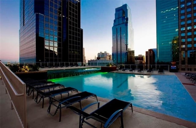 pool at dusk with a patio area