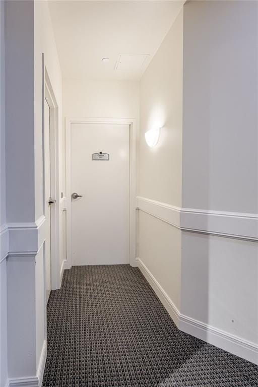 hallway featuring dark carpet