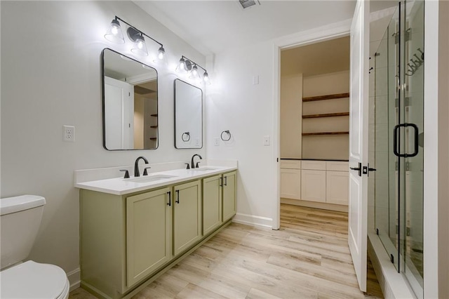 bathroom featuring vanity, toilet, hardwood / wood-style flooring, and walk in shower