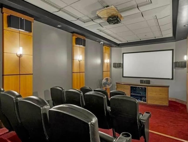 home theater room featuring carpet and a paneled ceiling