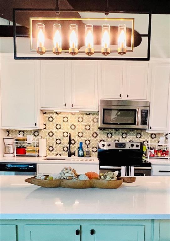 kitchen with tasteful backsplash, appliances with stainless steel finishes, blue cabinets, and sink