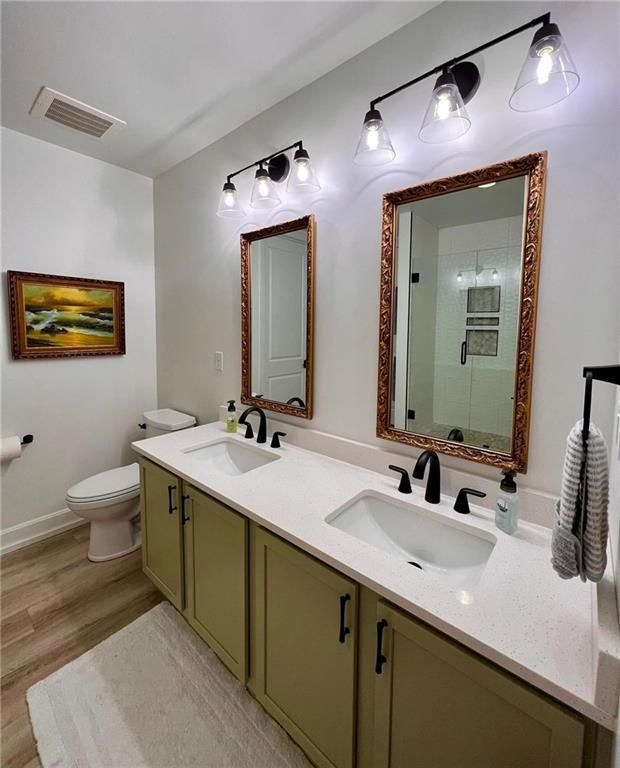 bathroom with vanity, hardwood / wood-style flooring, toilet, and walk in shower