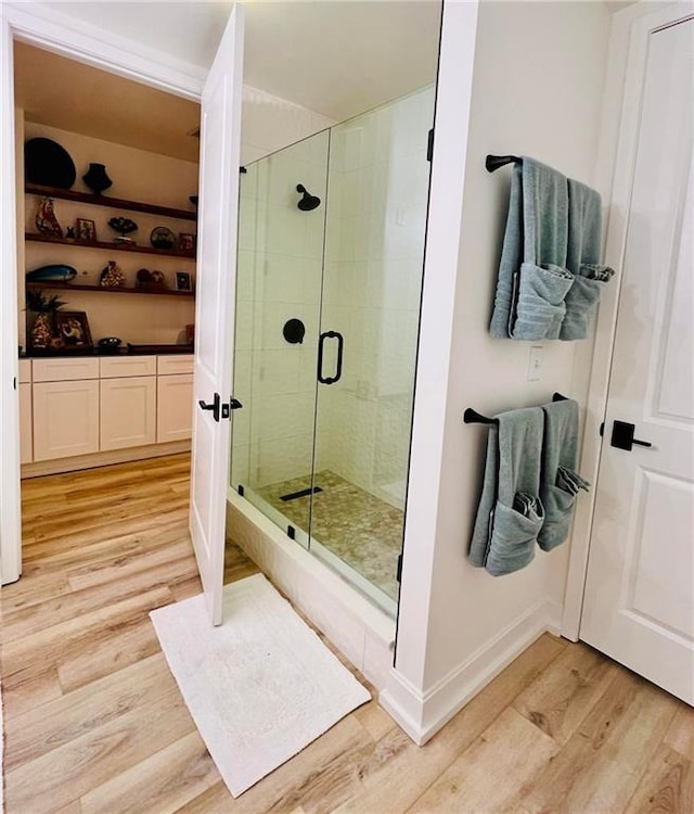 bathroom featuring hardwood / wood-style flooring and a shower with door