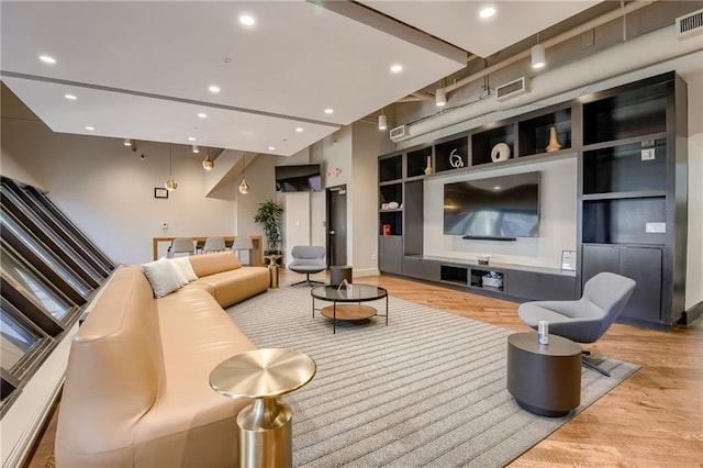 living room with light hardwood / wood-style flooring and built in features