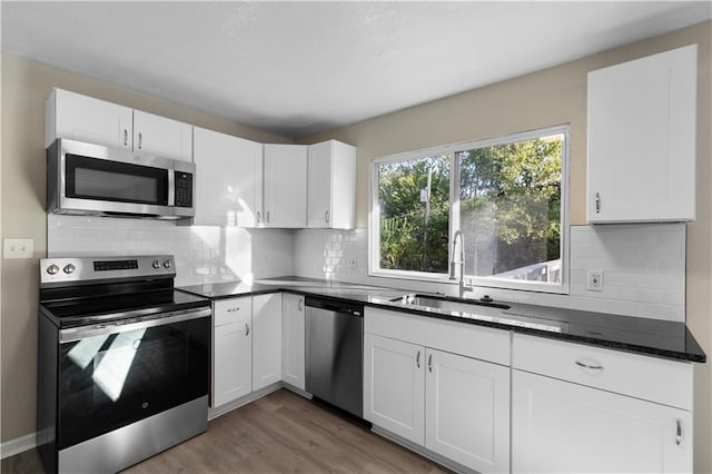 kitchen featuring white cabinetry, wood-type flooring, and appliances with stainless steel finishes