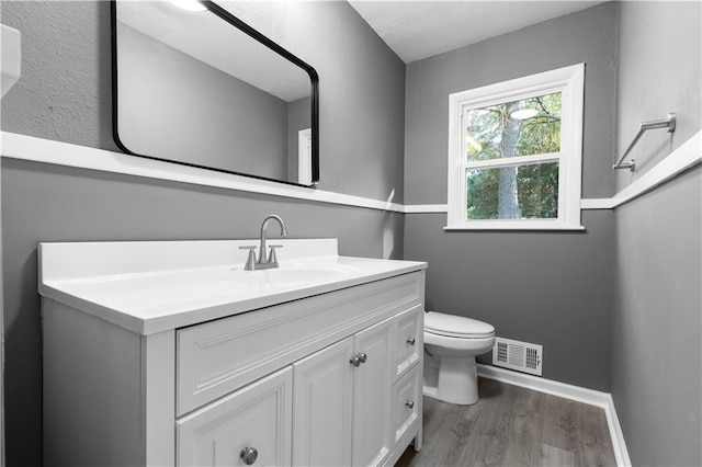 bathroom featuring vanity, wood-type flooring, and toilet