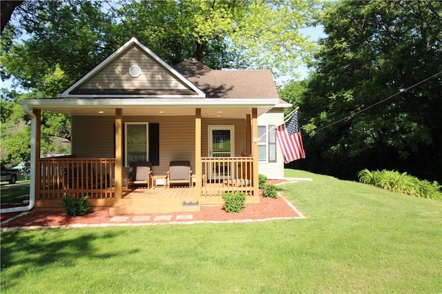 back of house featuring a lawn and covered porch