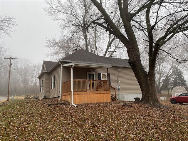 view of front of property featuring a shingled roof and a porch