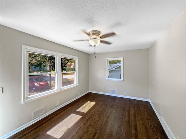 spare room featuring ceiling fan, dark hardwood / wood-style floors, and a textured ceiling