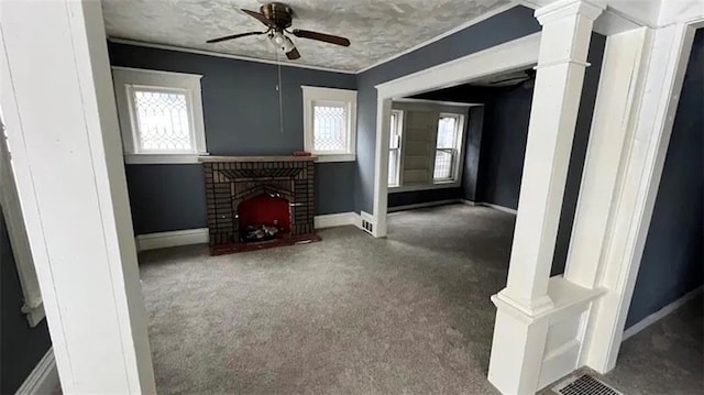 unfurnished living room with crown molding, a fireplace, dark colored carpet, and ceiling fan