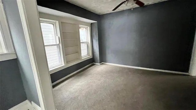 unfurnished room featuring concrete floors, ceiling fan, and plenty of natural light