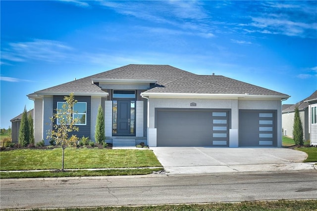 prairie-style house with a garage and a front lawn