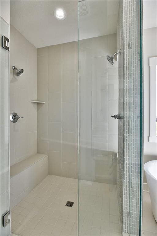 bathroom with independent shower and bath and tile patterned floors