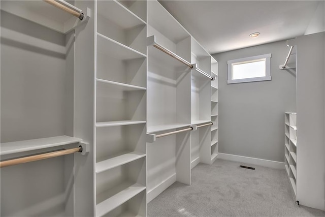 walk in closet featuring light colored carpet