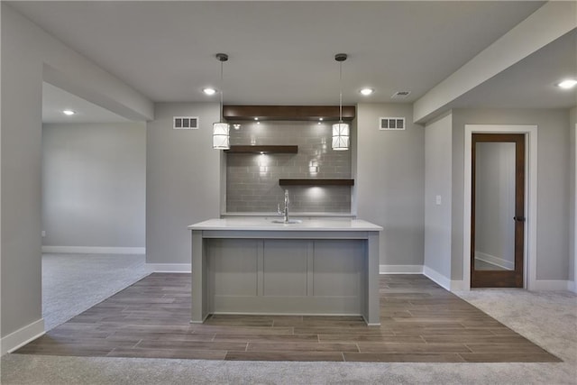 kitchen with dark hardwood / wood-style flooring, sink, decorative light fixtures, and tasteful backsplash