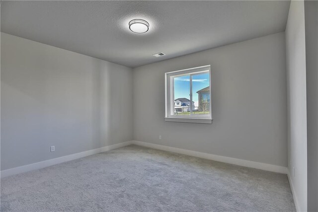 unfurnished room featuring a textured ceiling and carpet flooring