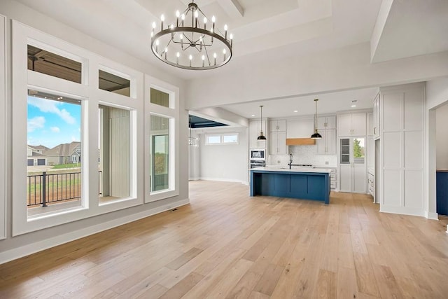 17504 Acton St, Overland Park, KS 66085 - unfurnished living room with a sink, a chandelier, light wood finished floors, baseboards, and recessed lighting